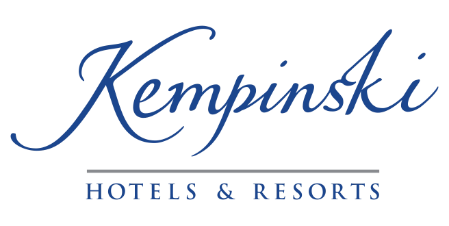 Blauer Schriftzug Kempinski Hotels & Resorts in eleganter Schreibschrift über einer grauen Linie auf schwarzem Grund.